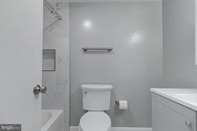 a white toilet sitting next to a bathroom sink