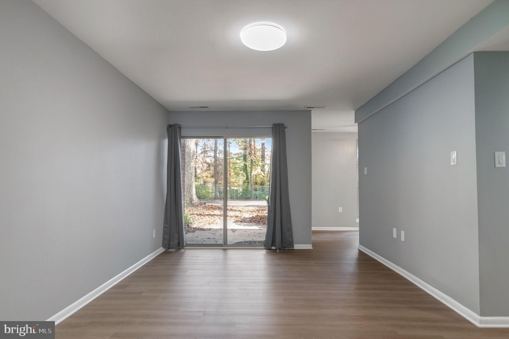 3356 Woodburn Road, Unit T3 Annandale, VA 22003 - Photo 5 of 35 a view of an empty room with wooden floor and a window
