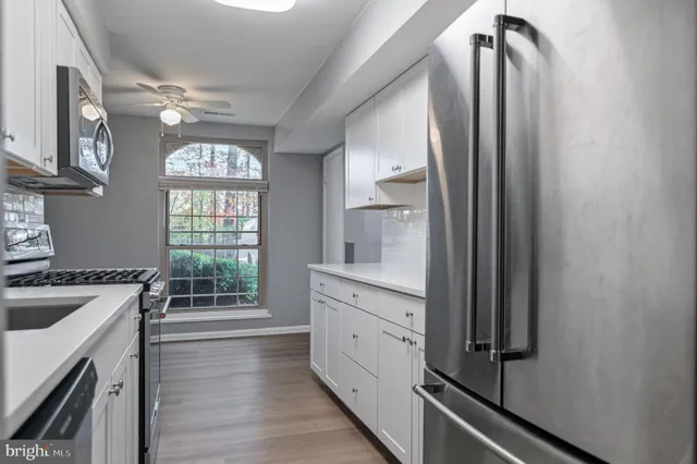 a kitchen with granite countertop white cabinets and white appliances