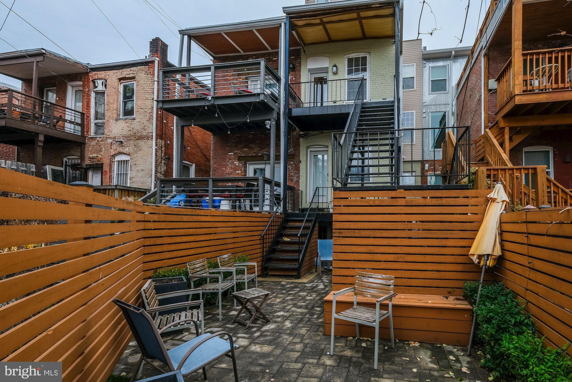 1730 1st Street Northwest, Unit 2 Washington, DC 20001 - Photo 23 of 27 a view of a patio with table and chairs with wooden floor and fence