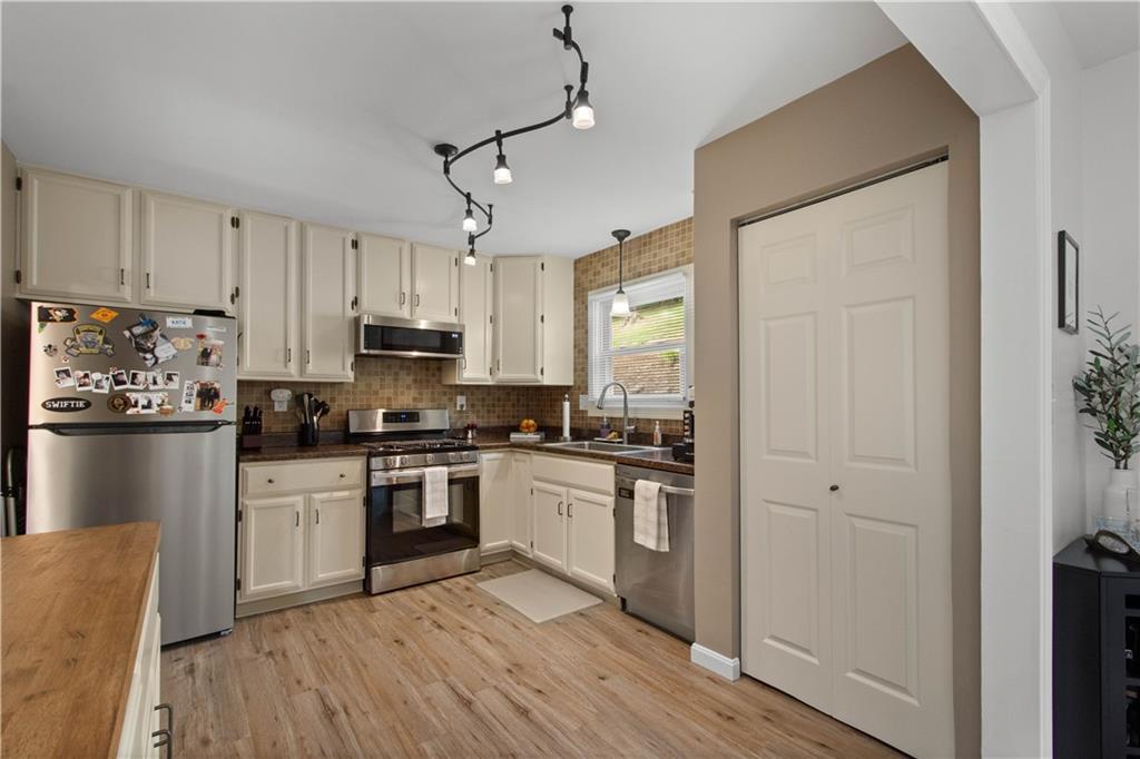 227 Davidson Drive Charleroi, PA 15022 - Photo 8 of 40 a kitchen with stainless steel appliances granite countertop a refrigerator a stove top oven a sink and dishwasher with wooden floor