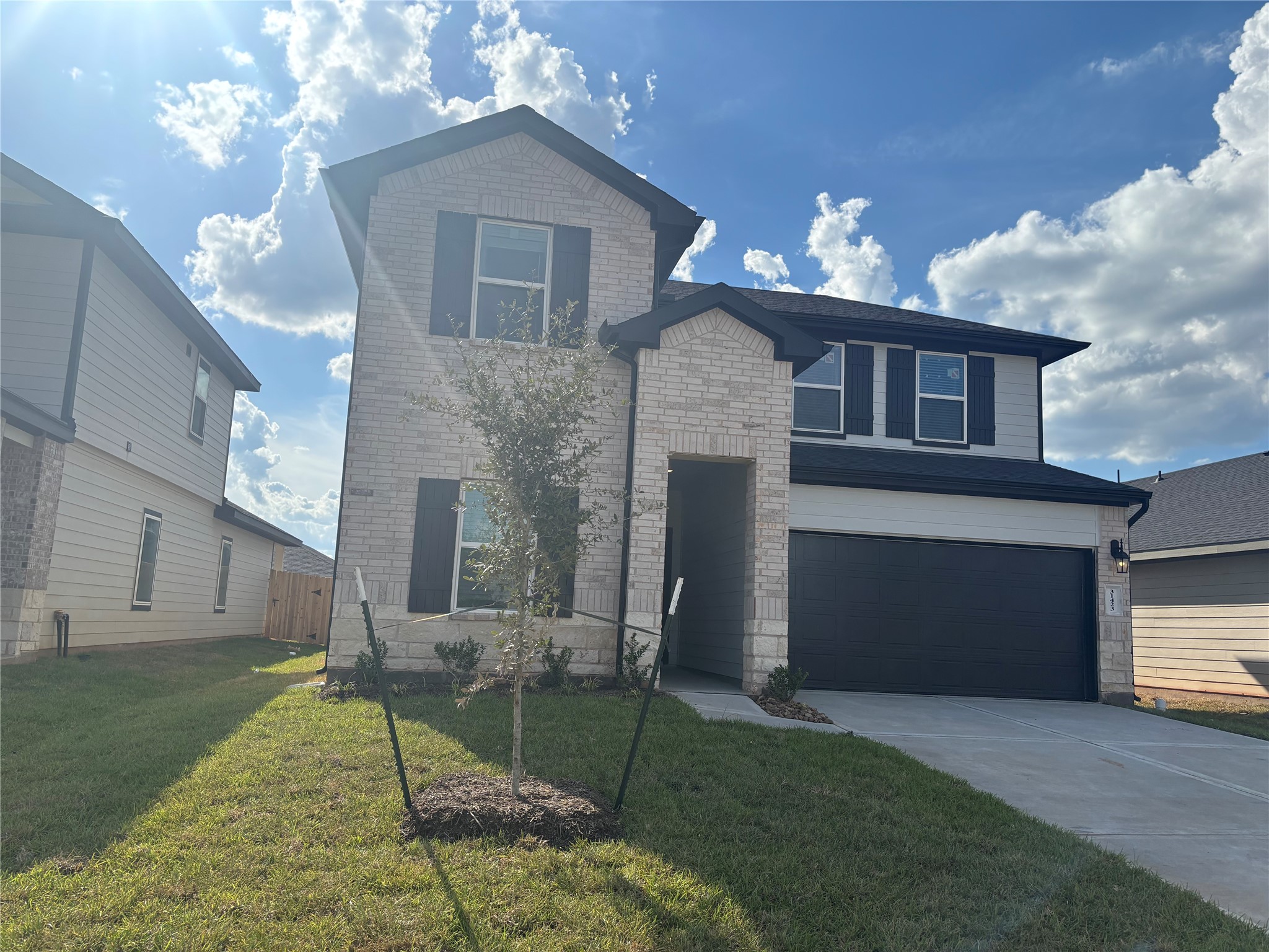 31423 Harp Ridge Drive Fulshear, TX 77441 - Photo 2 of 45 Charming two-story home featuring a modern brick facade, double garage, and a neat front lawn, perfect for family living.