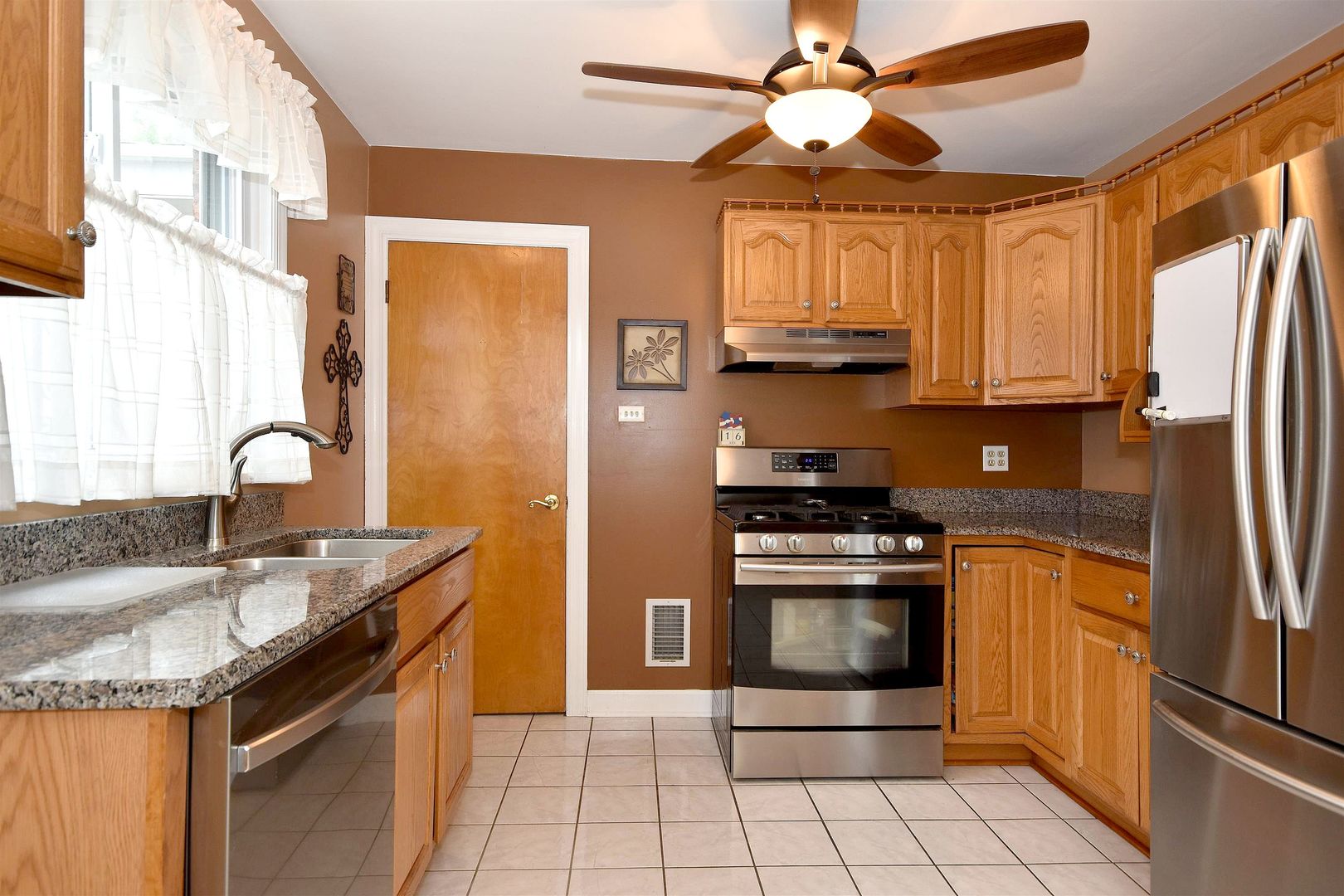 8423 Riverside Avenue Brookfield, IL 60513 - Photo 10 of 28 a kitchen with stainless steel appliances granite countertop a sink stove and refrigerator
