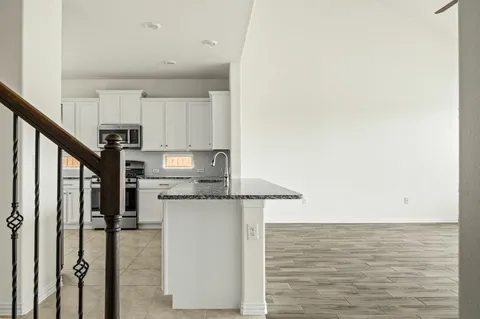 a kitchen with stainless steel appliances granite countertop a refrigerator and a stove