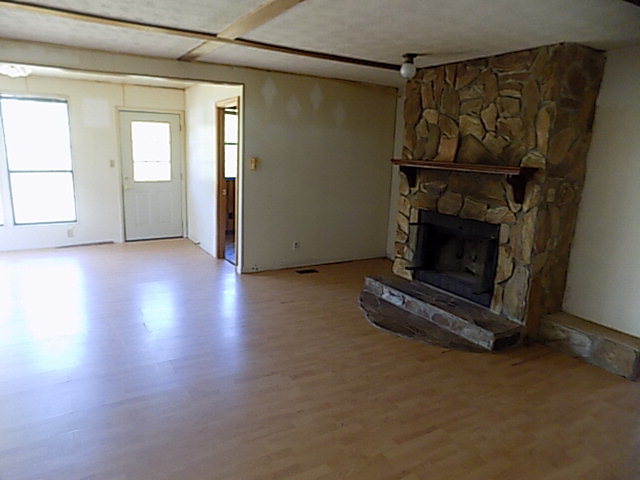 3294 South Lizella Road Lizella, GA 31052 - Photo 12 of 17 an empty room with wooden floor fireplace and windows