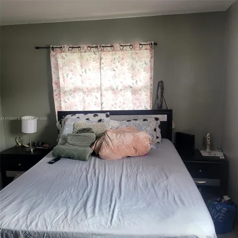 a bed sitting in a bedroom next to a window