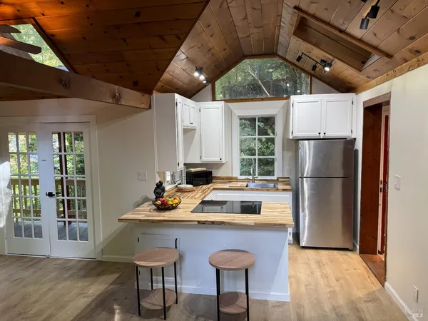 a kitchen with a table chairs refrigerator and cabinets