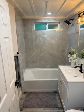 a bathroom with a tub sink and mirror
