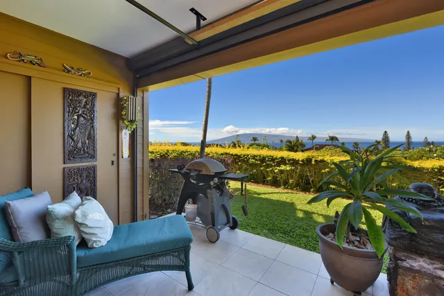 a living room with patio furniture and potted plants