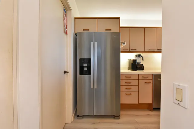 a kitchen with white cabinets and refrigerator