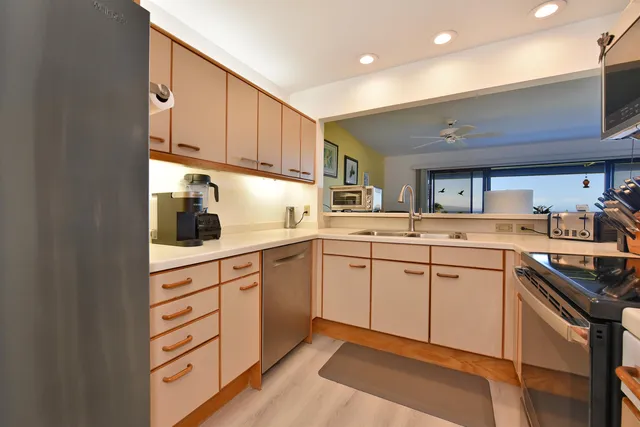 a kitchen with cabinets appliances and a window