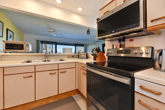 a kitchen with stainless steel appliances a stove microwave and cabinets