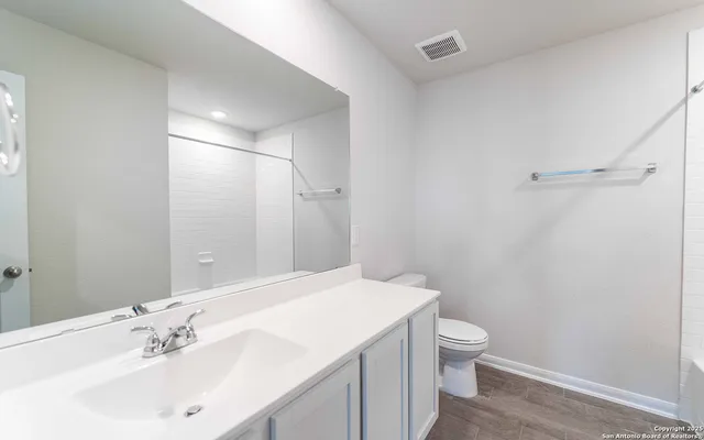 a bathroom with a sink a toilet and shower