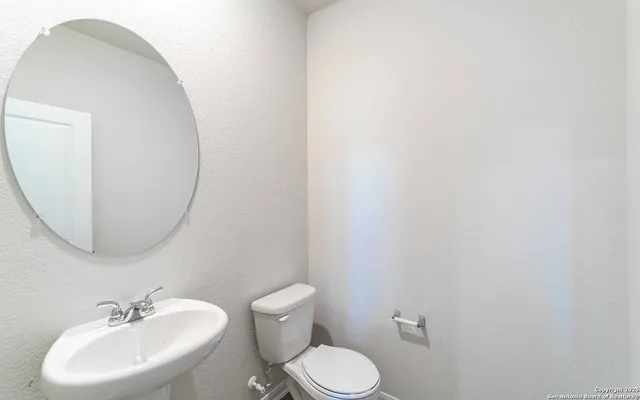 a bathroom with a toilet sink and mirror