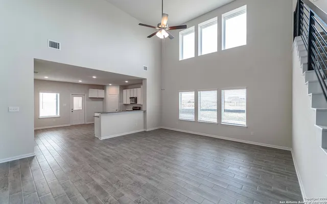 a view of an empty room with window and wooden floor