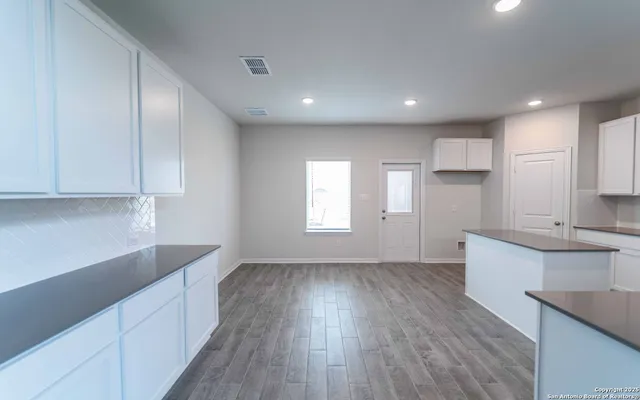 a kitchen with granite countertop a sink and wooden floor