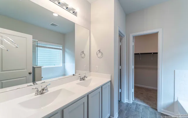 a bathroom with a sink double vanity and a mirror