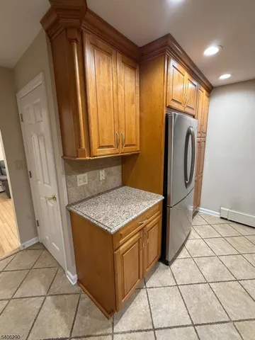 a kitchen with stainless steel appliances granite countertop a refrigerator a sink a microwave oven and cabinets