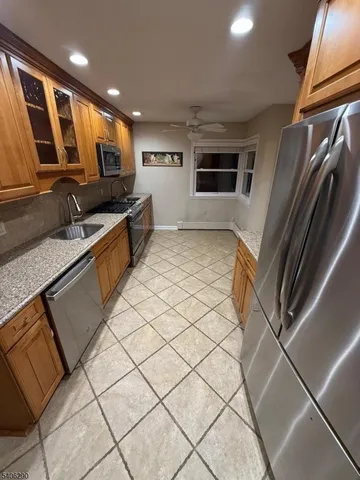 a large kitchen with a stove a sink dishwasher and a refrigerator