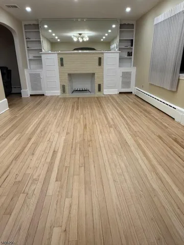 wooden floor in an empty room with a kitchen