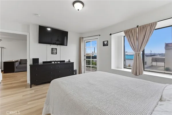 a large bedroom with a bed and a flat screen tv