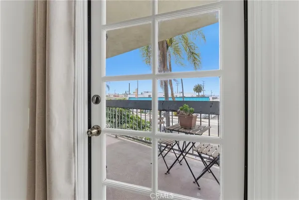 a view of a bedroom with wooden floor and a shelf