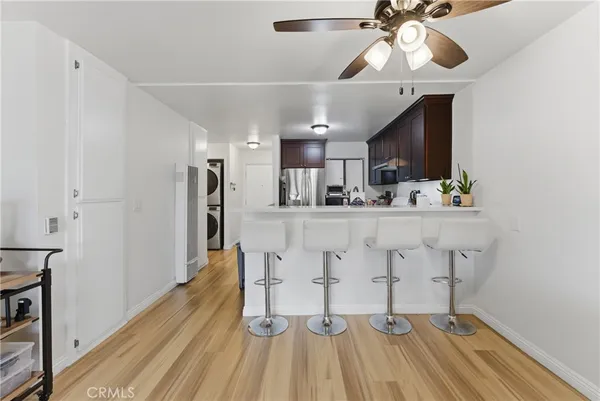 a kitchen with kitchen island stainless steel appliances a dining table chairs sink and cabinets