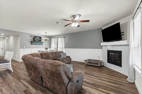 a living room with furniture a flat screen tv and a fireplace