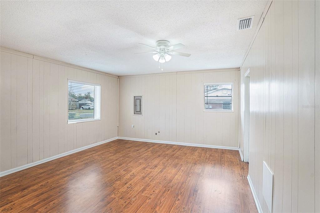 2527 Ridge Top Way Valrico, FL 33594 - Photo 6 of 29 an empty room with wooden floor chandelier fan and windows