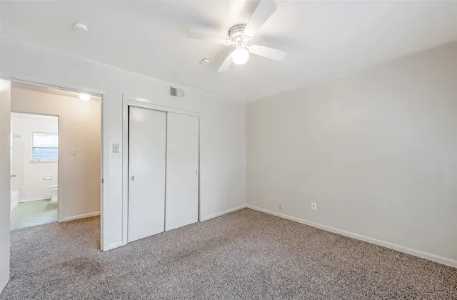 an empty room with fan and entryway