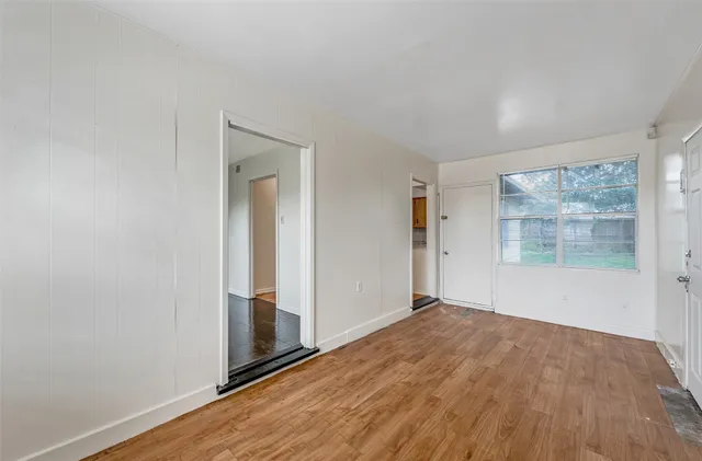 an empty room with wooden floor and a window