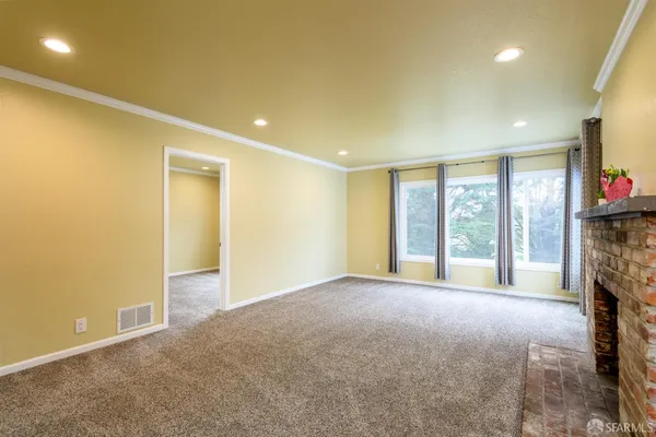 a view of an empty room with a fireplace
