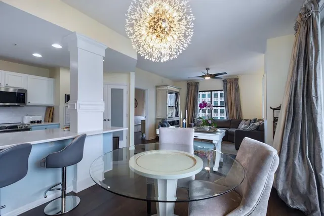 a dining room with furniture a chandelier and wooden floor