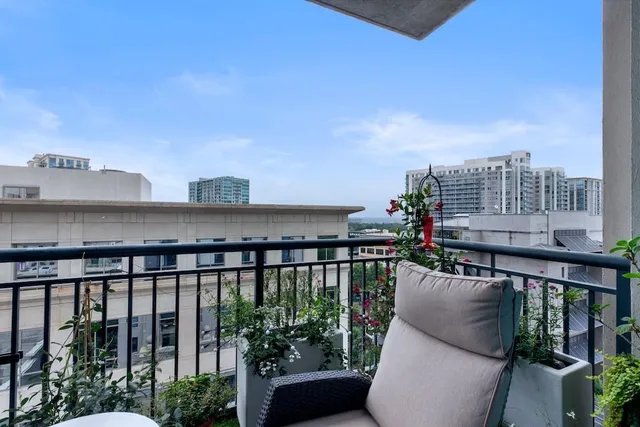 a view of a balcony with chairs and wooden fence