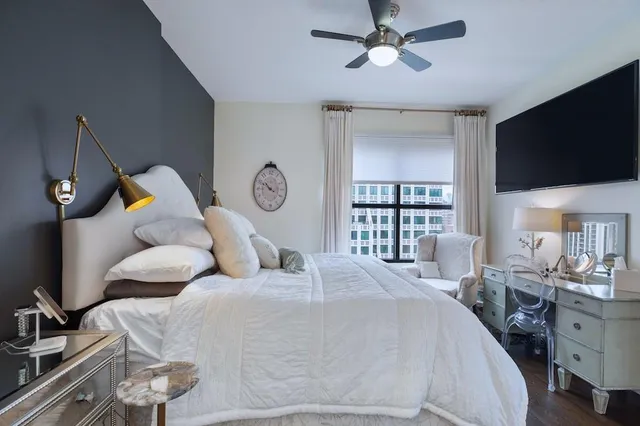 a bedroom with a large bed and a flat tv screen on dresser