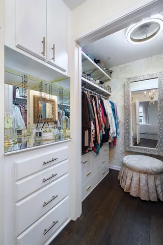 a view of walk in closet with clothes and shoes