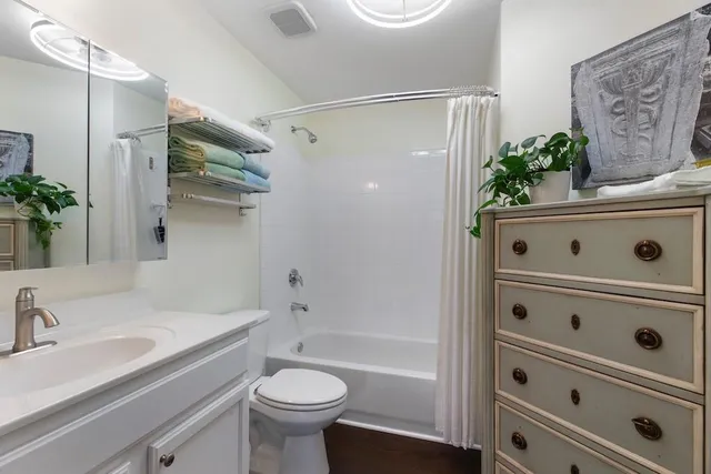 a bathroom with a shower sink vanity mirror and toilet