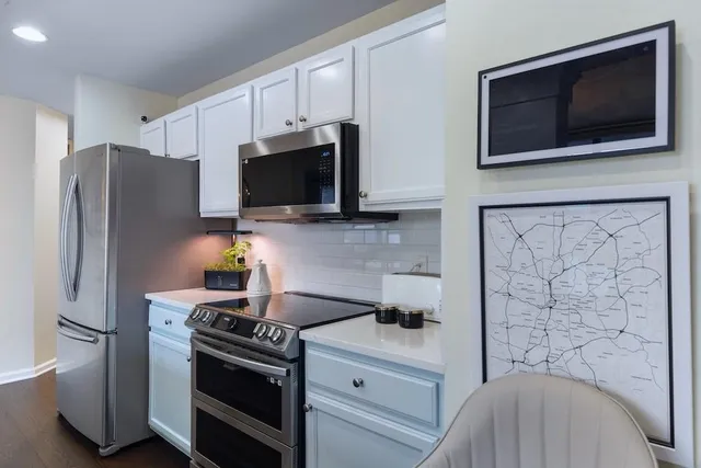 a kitchen with stainless steel appliances a stove microwave and refrigerator