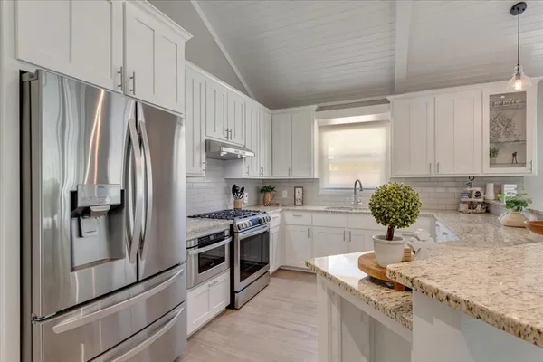 a kitchen with stainless steel appliances granite countertop a sink stove and refrigerator