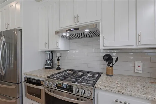 a kitchen with granite countertop a stove and a refrigerator
