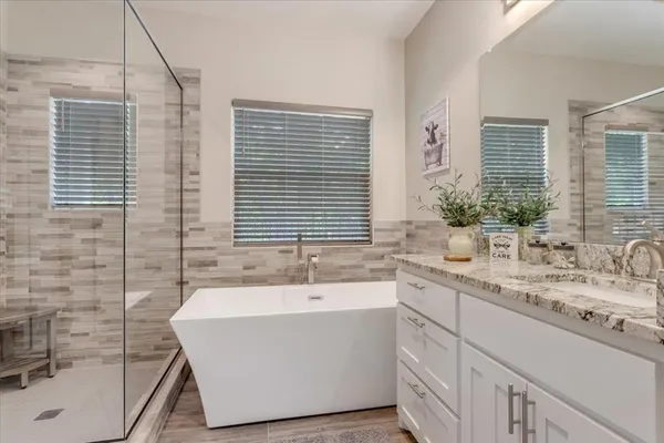 a bathroom with a tub sink and mirror