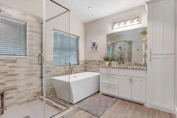 a spacious bathroom with a double vanity sink a mirror and a bathtub