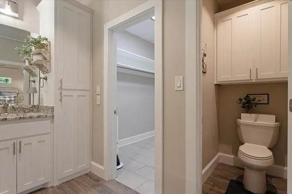 a bathroom with a granite countertop toilet and a sink