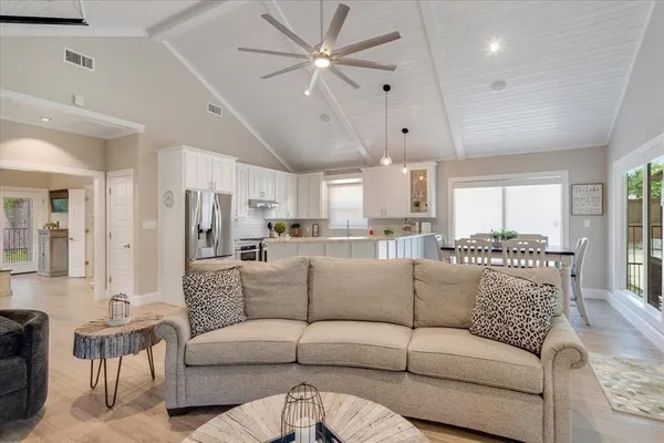 a living room with furniture white walls and kitchen view