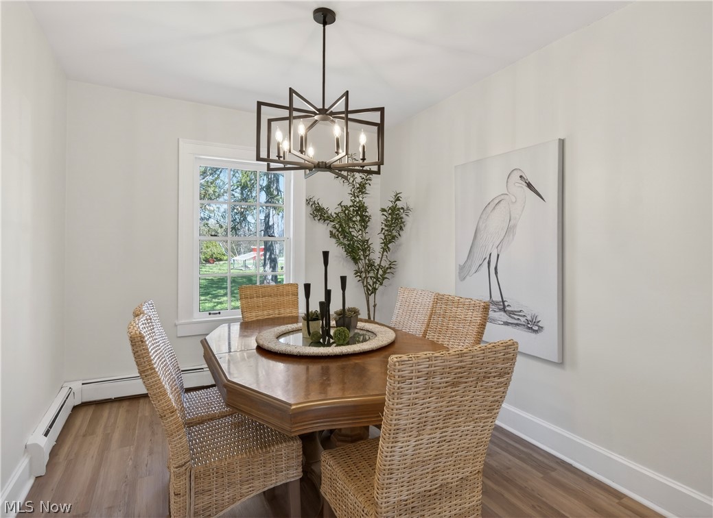 14939 Caves Road Novelty, OH 44072 - Photo 14 of 42 Dining room featuring wood finished floors, suspended lighting, and a baseboard heating unit