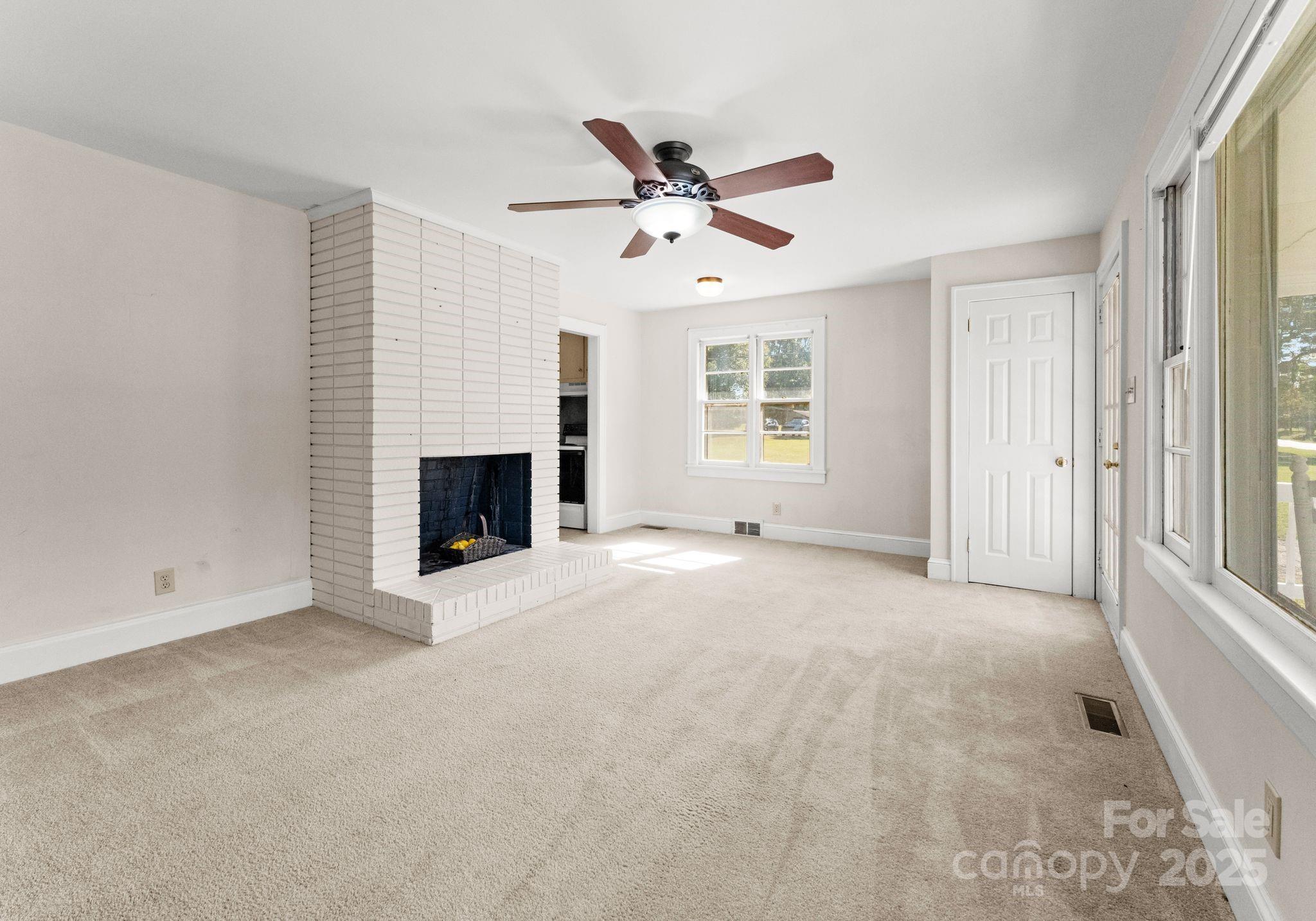 5170 Woodleaf Road Salisbury, NC 28147 - Photo 3 of 13 an empty room with windows and fireplace