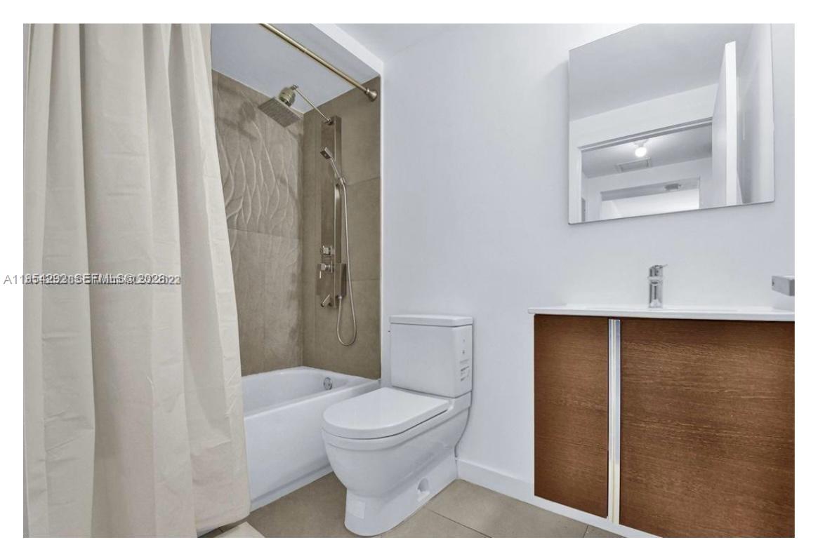 557 Michigan Avenue, Unit 111 Miami Beach, FL 33139 - Photo 11 of 13 a bathroom with a toilet a sink and shower