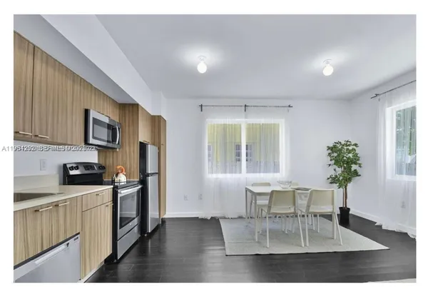 a living room with furniture potted plant a refrigerator and a potted plant