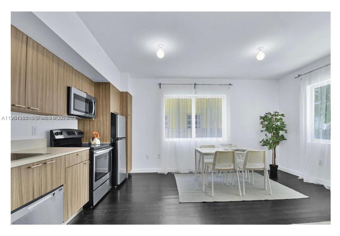 557 Michigan Avenue, Unit 111 Miami Beach, FL 33139 - Photo 3 of 13 a living room with furniture potted plant a refrigerator and a potted plant
