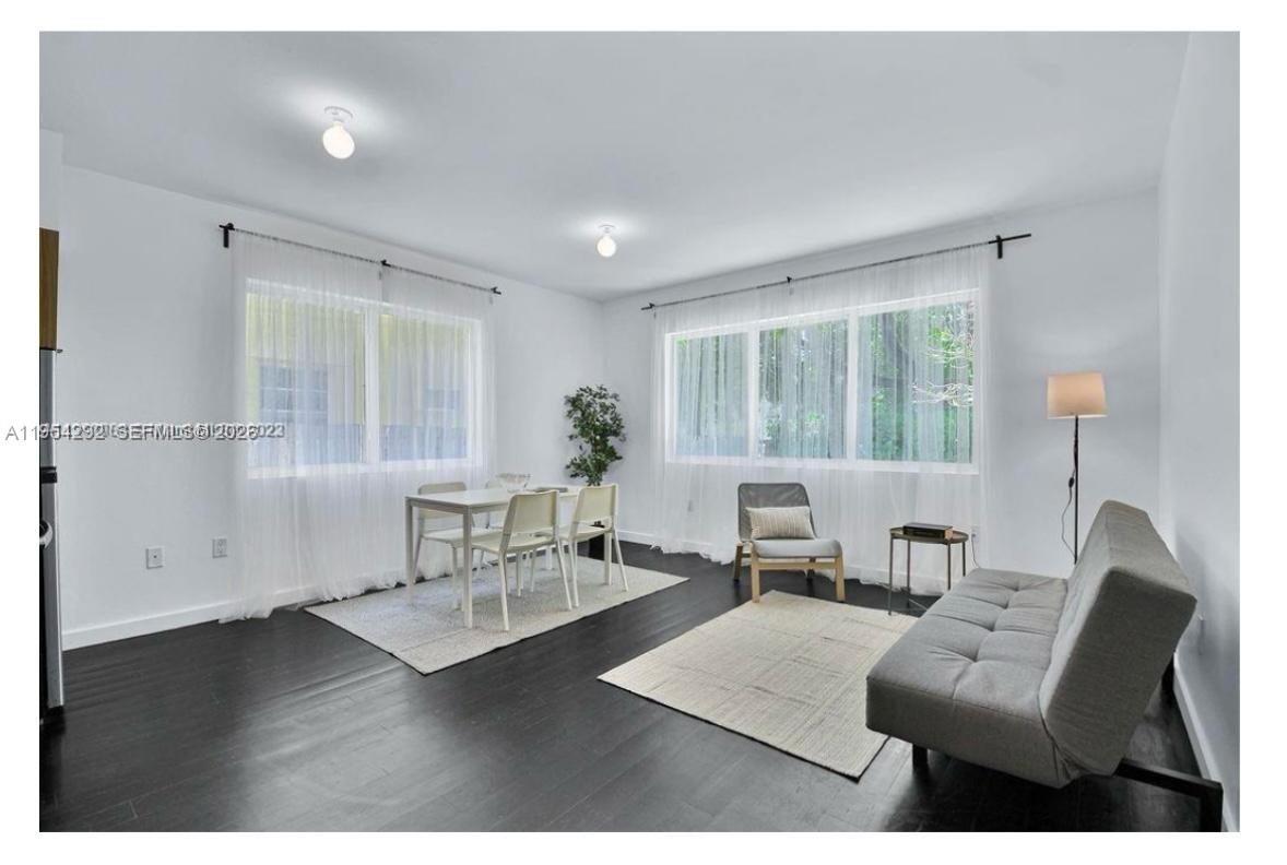 557 Michigan Avenue, Unit 111 Miami Beach, FL 33139 - Photo 5 of 13 a living room with furniture and wooden floor